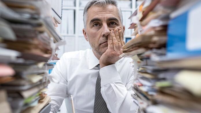 Frustrated executive overloaded with paperwork