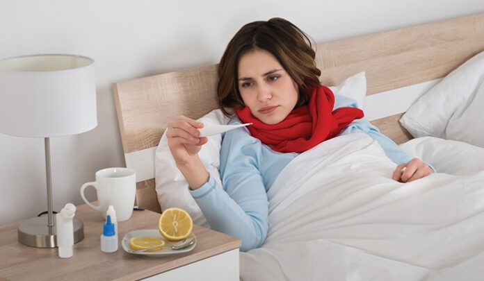 Sick Woman Looking At Thermometer