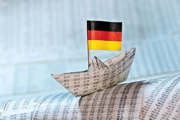 Papierschiff mit deutscher Flagge auf Börsennachrichten