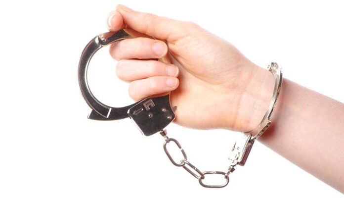 Hand wearing handcuffs