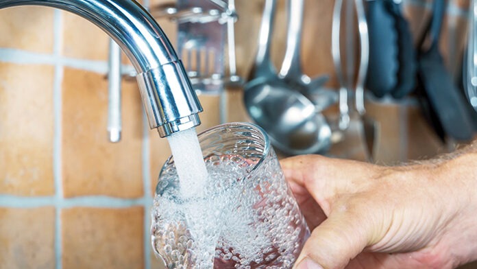 frisches Wasser in ein Glas gießen.