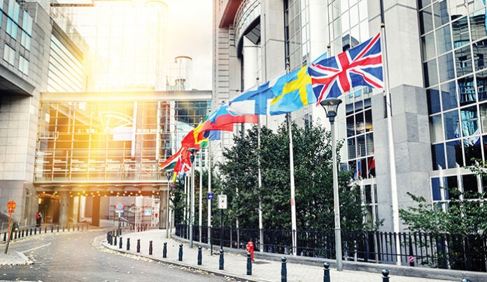 Waving flags in front of European Parliament building. Brussels,