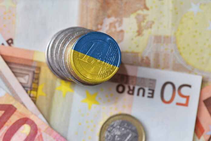 euro coin with national flag of ukraine on the euro money banknotes background