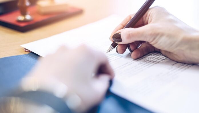 Woman notary public signing last will testament document