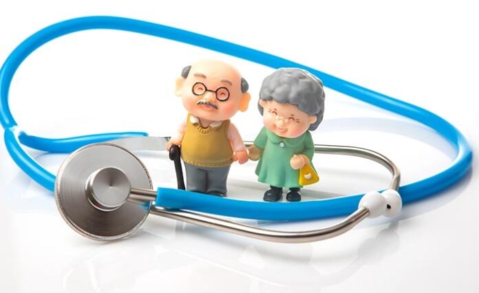 miniature people. Stethoscope and figurines of pensioners on a w