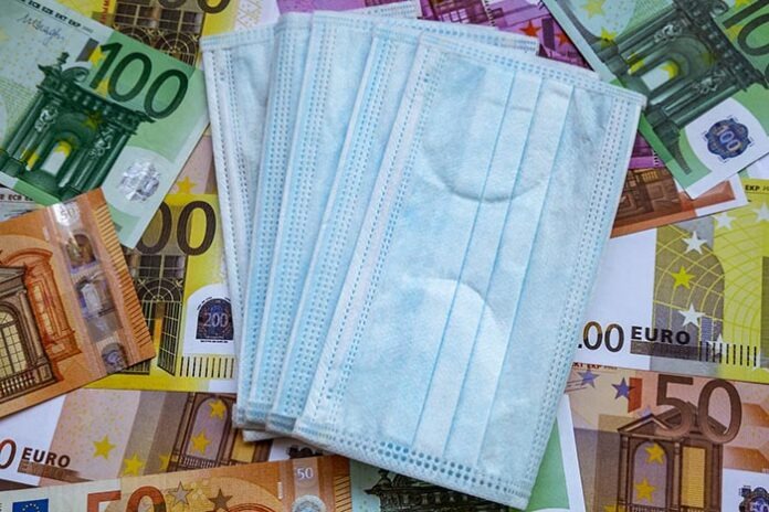 Euro banknotes and a protective mask against coronavirus. The virus in Europe