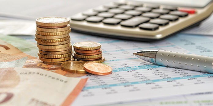 Geld mit Taschenrechner und Kugelschreiber