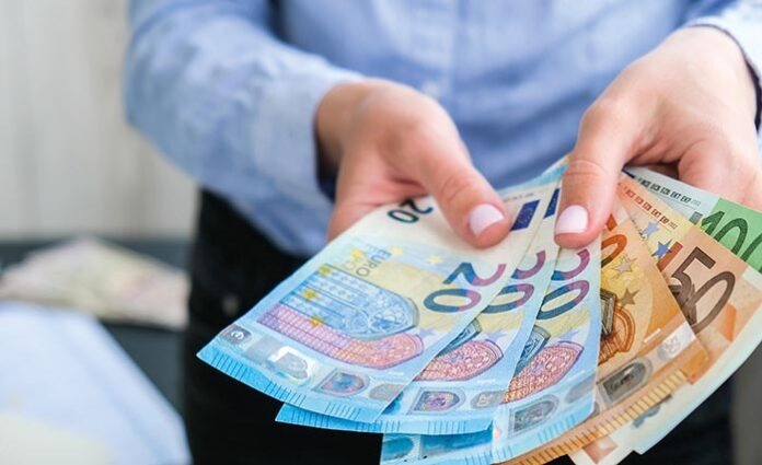 Business Woman Displaying a Spread of Cash euros. Close-up. Income and Business concept. Venality, bribe, corruption concept. Hand giving money. Millennial candid authentic female hands counting money
