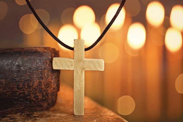 Wooden cross against defocused lights