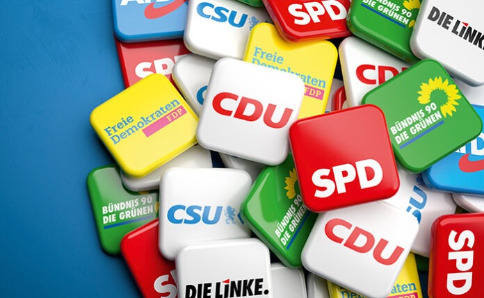 Logos of the biggest German political parties (CDU CSU, SPD, Die Grünen, FDP, Die Linke, AfD) running for the Bundestag election on a heap on a table. Copy space.