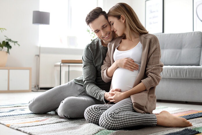 Young pregnant woman with her husband at home