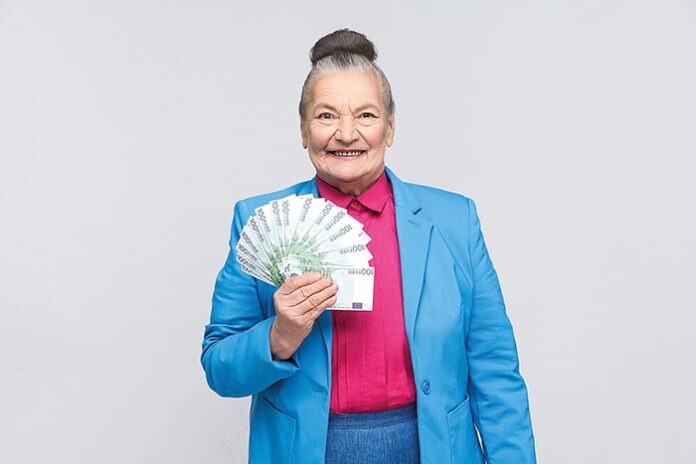 Happy adult woman holding many euro