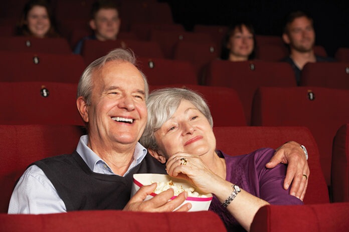 Senior Couple Watching Film In Cinema