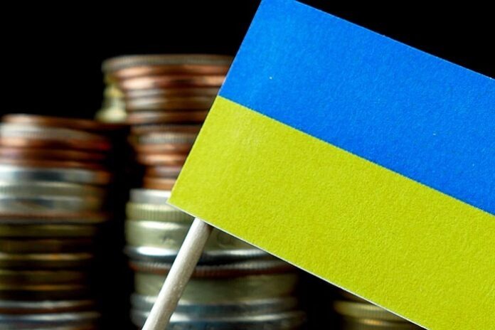Ukraine flag waving with stack of money coins macro