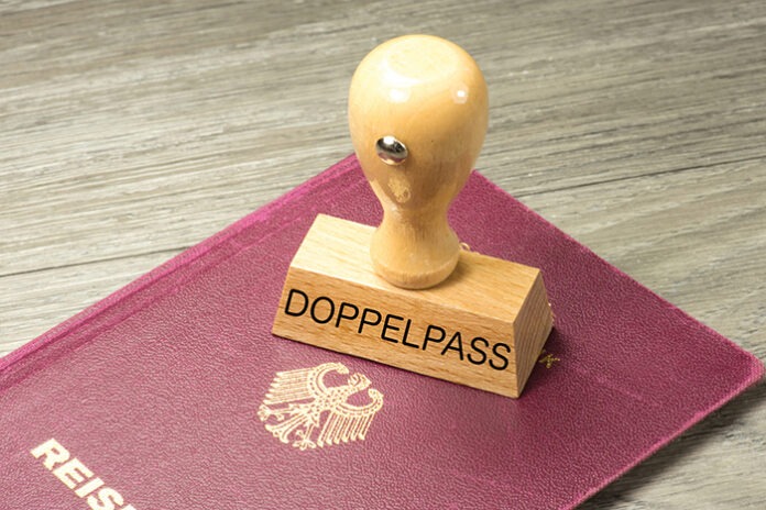 Ein deutscher Reisepass und ein Stempel mit dem Aufdruck Doppelp