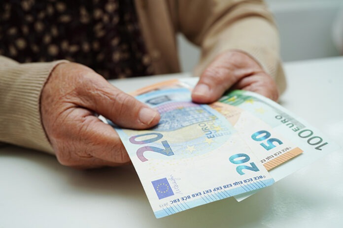 Retired elderly woman holding Euro banknotes money and worry abo