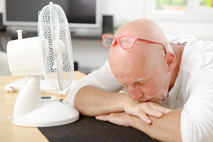 mature man refreshed with a fan
