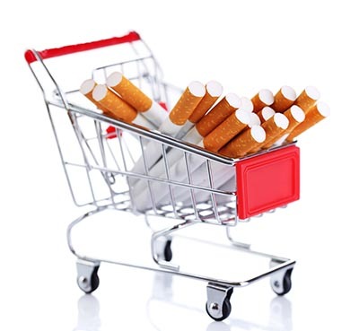 Cigarettes in shopping cart isolated on white