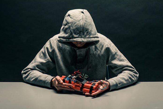 Terrorist is holding home made bomb with cables and remote contr
