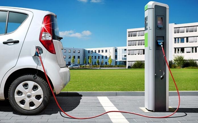 Elektroauto an Stromtankstelle vor Brogebude Elektromobilitt