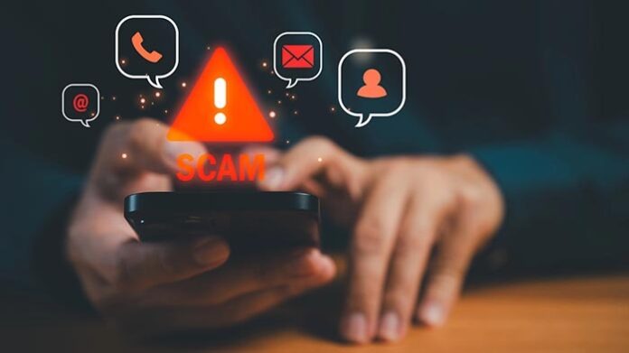 Close-up of hands holding smartphone with glowing scam warning i