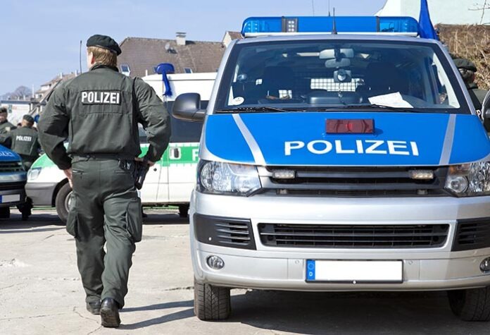 Polizist neben Einsatzwagen